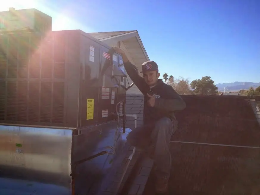 HVAC technician performing AC Tune-Up on a rooftop unit in Martinsville